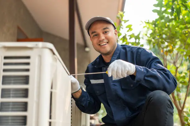 HVAC handyman inspecting an air conditioning unit